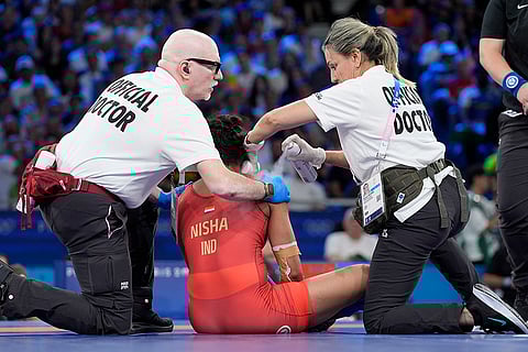 Nisha Dahiya receives medical attention during women's freestyle 68kg wrestling quarterfinal